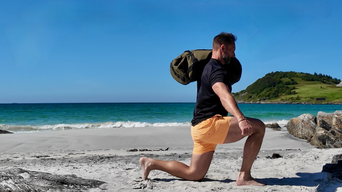 René beim Krafttraining mit Sandsack am Strand – effektive Übung zur Vorbeugung von Sarkopenie und Erhalt der Muskelmasse im Alter